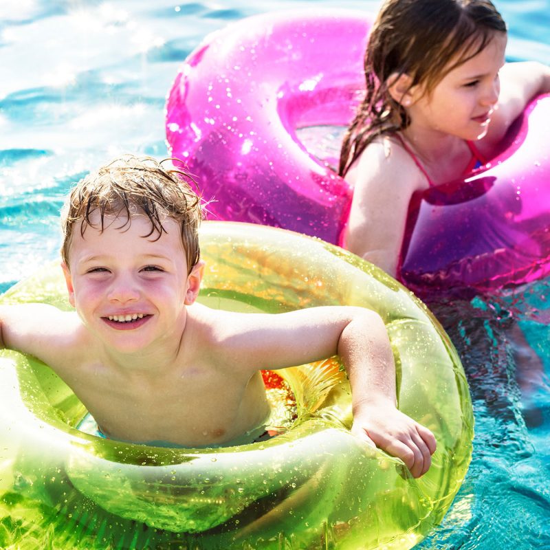 Enfants avec des bouées jouant dans une piscine