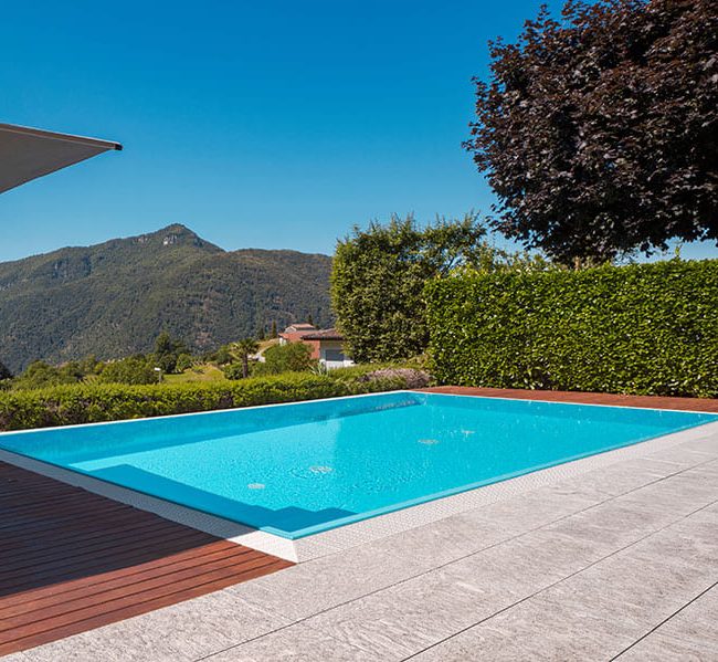 Piscine creusée avec terrasse en dalles et bois