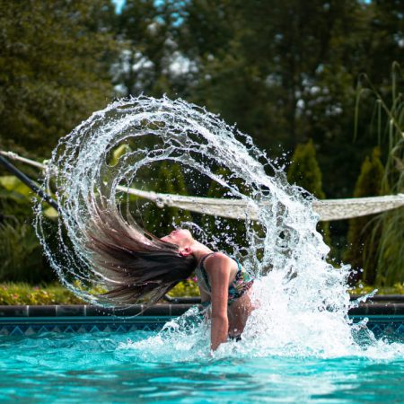 Jeune femme dans une piscine avec hamac en fond